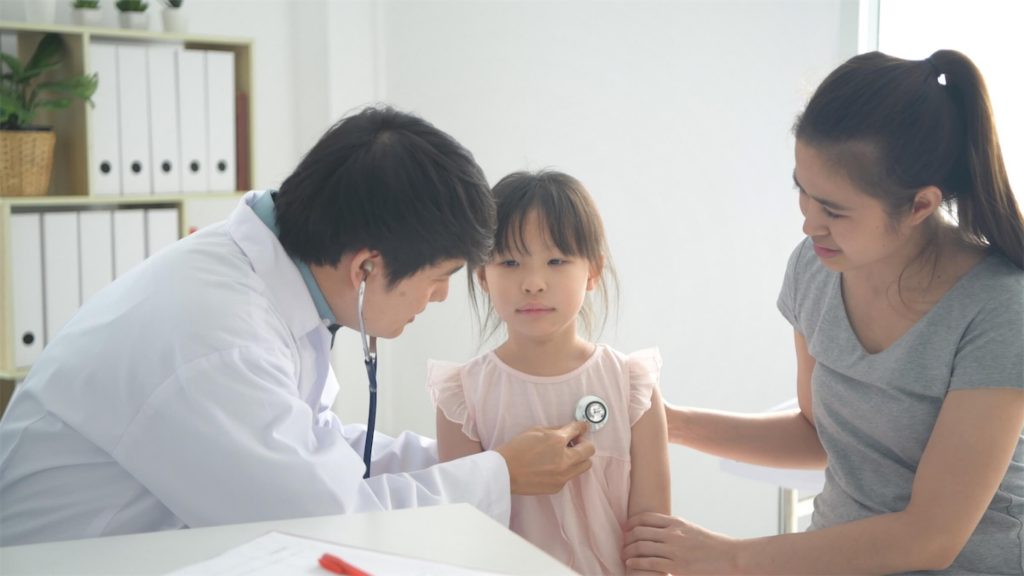 Young girl having a medical check-up with the doctor at the clinic for her 100 days cough symptoms